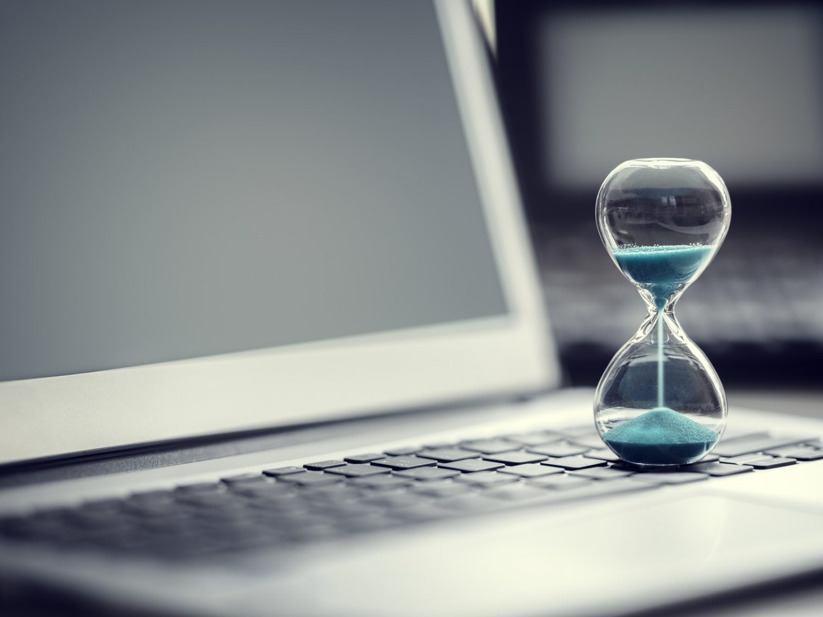 Hourglass on laptop computer concept for time management Hourglass on laptop computer concept for time management